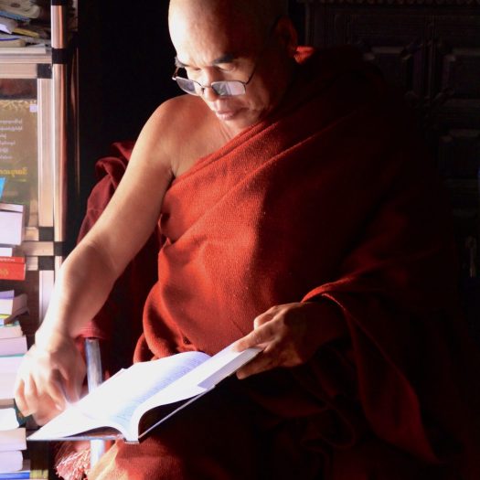 Image of a monk reading scriptures